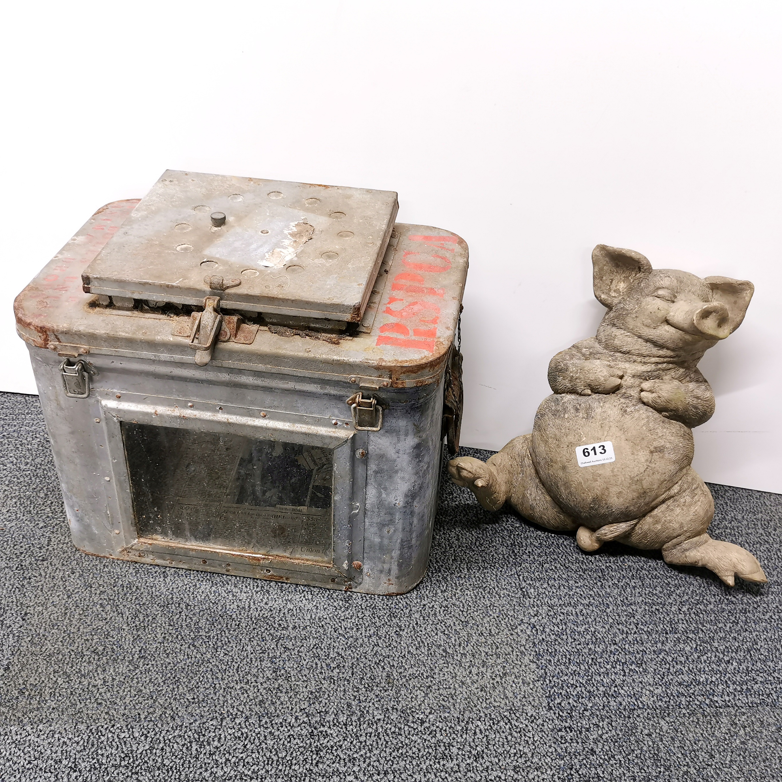 A vintage zinc animal carrier and a garden figure of a pig.