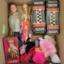 A group of Sindy and Paul dolls with accessories and two Scalextric racing cars.