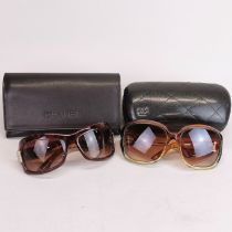 Two pairs of vintage sunglasses with two Chanel cases.