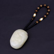 A Chinese polished mutton fat jade pebble, carved with Qilin and crane, pebble size 7cm.