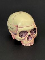 A pill box in the form of a skull, H. 4cm, L. 5cm.