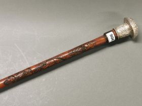 A Japanese carved bamboo sword stick with ornate silvered metal handle, L. 90cm.