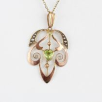 An Art Nouveau 9ct gold pendant set with a heart cut peridot and pearls on a 9ct yellow gold