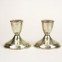 A pair of weighted sterling silver candle sticks, H. 8cm.