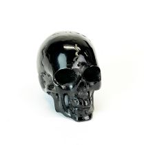 A hand carved water buffalo black horn human skull, H. 2.8cm.