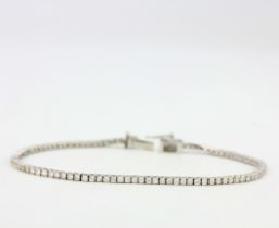 An 18ct white gold (stamped 18ct) diamond set tennis bracelet, L. 18.5cm. With W.G.I. certificate,