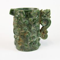 An impressive dark green carved jade wine jug relief decorated with dragons, H. 16cm.