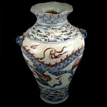 A Chinese provincial hand painted porcelain vase decorated with a dragon and script, H. 43cm, W.