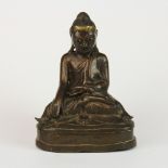 A Burmese bronze figure of a seated Buddha with glass eyes, circa 1900, H. 16cm.