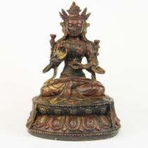 A Tibetan painted and gilt bronze figure of a seated deity, H. 26cm.