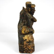 A Qing Dynasty Chinese carved wooden figure sitting on a mythical creature, H. 22.5cm.