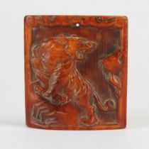 A Tibetan carved yak bone amulet of a tiger on a rock, 5 x 5cm.