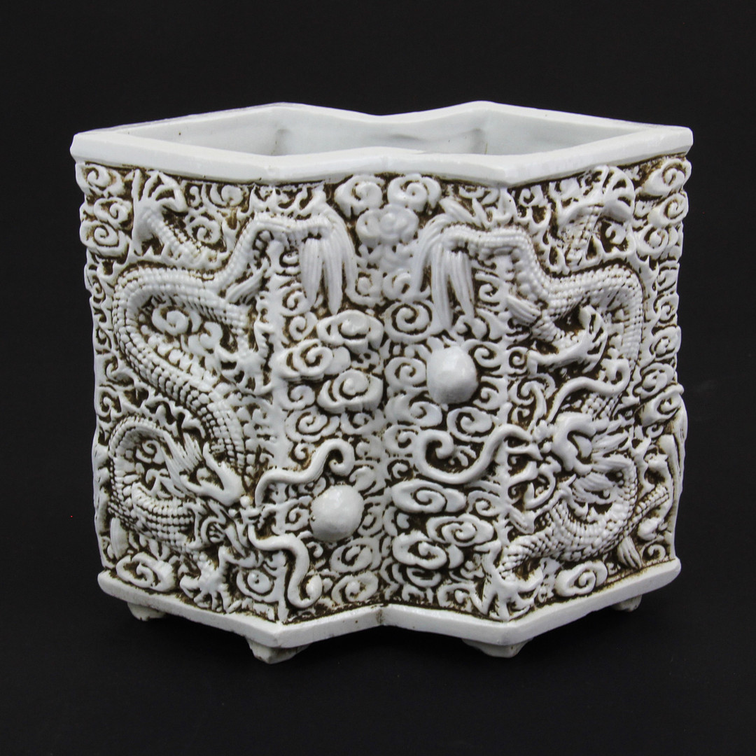 A Chinese relief decorated porcelain brush pot, H. 13.1cm.
