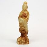 A Chinese celadon and russet jade figure of the goddess Guanyin. H. 18 cms