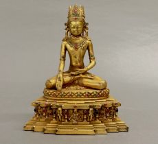 A Tibetan bronze stone set figure of the seated Buddha, H. 27cm.