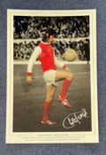 Football. Charlie George Signed 18x12 colourised photo. Photo shows George doing keepy uppies in