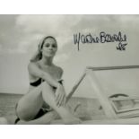 Martine Beswick signed 10 x 8 inch b/w in swim suit sitting on Motor Boat. James Bond 007 Actress.