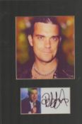 Robbie Williams signed 12x8 mounted piece. Good condition. All autographs are genuine hand signed
