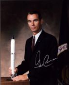Gene Cernan signed 10x8 inch colour photo pictured in suit sitting behind desk. From single vendor