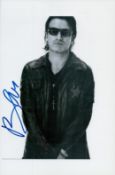 Bono signed 10x7 inch black and white photo. Good condition. All autographs are genuine hand