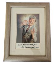 Sir Norman Wisdom signed colour photo. Mounted and framed to approx size 8x6inch. Good condition.