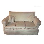 A cream with pink piping upholstered three-seat sofa