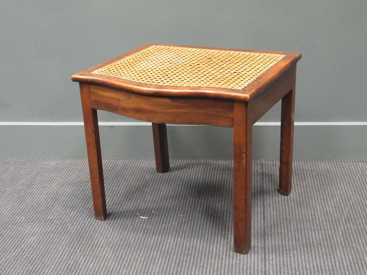 A cane work mahogany stool, 19th century, the serpentine hinged seat enclosing a smaller