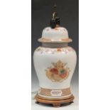 A large ceramic baluster lamp enamelled with a crest on a turned wood stand, approx 65cm high