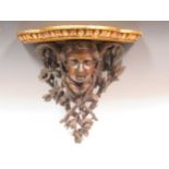 A Black Forest carved wood winged putto wall bracket, 19th century, with later added gilt top,