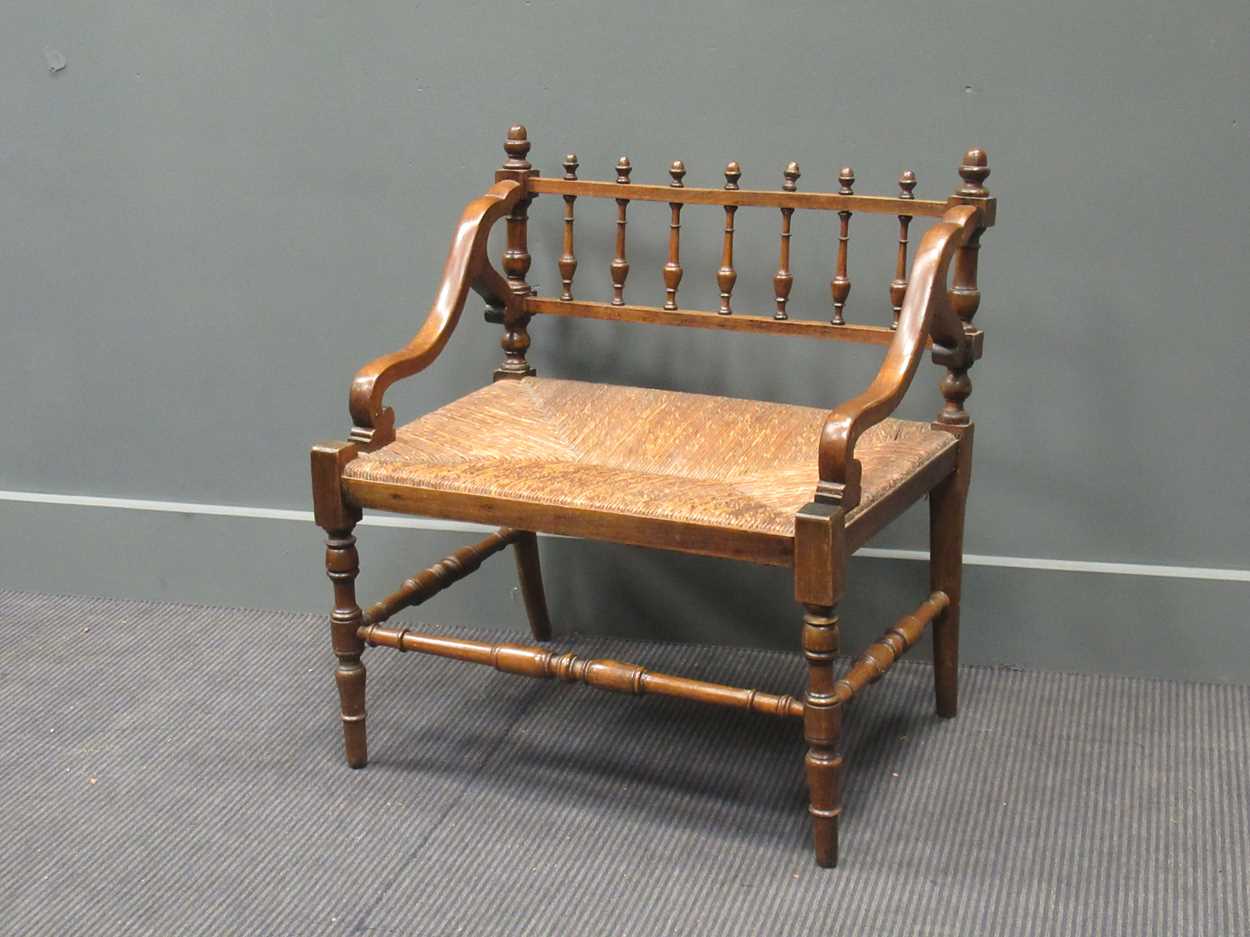 A 19th century rush seated hall chair, with down swept armsThe wood is stained beech.