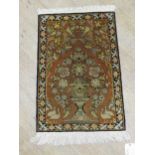 A small Persian silk rug 86 x 51cm, together with a Bokhara rug 200 x 130cm and a pink ground rug