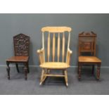 Two late Victorian oak hall chairs, a 20th century pale wood rocking armchair with turned frame