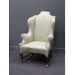 A William & Mary style wing-back armchair with part restored feet