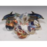 A collection of Royal Crown Derby paperweights, including two dolphins, a duck, a mallard duck, a
