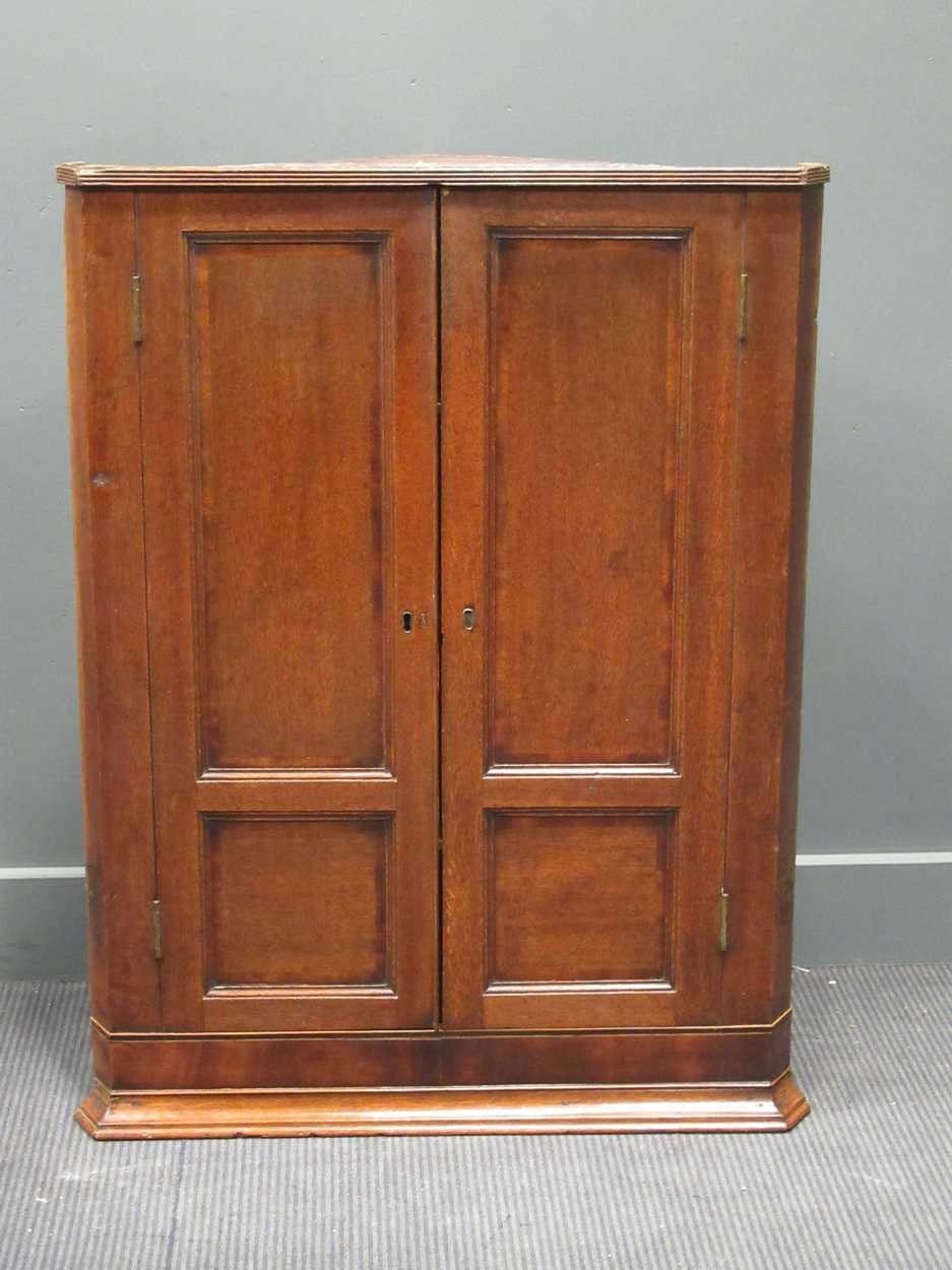 A George III oak hanging corner cupboard, 106 x 80 x 41cm