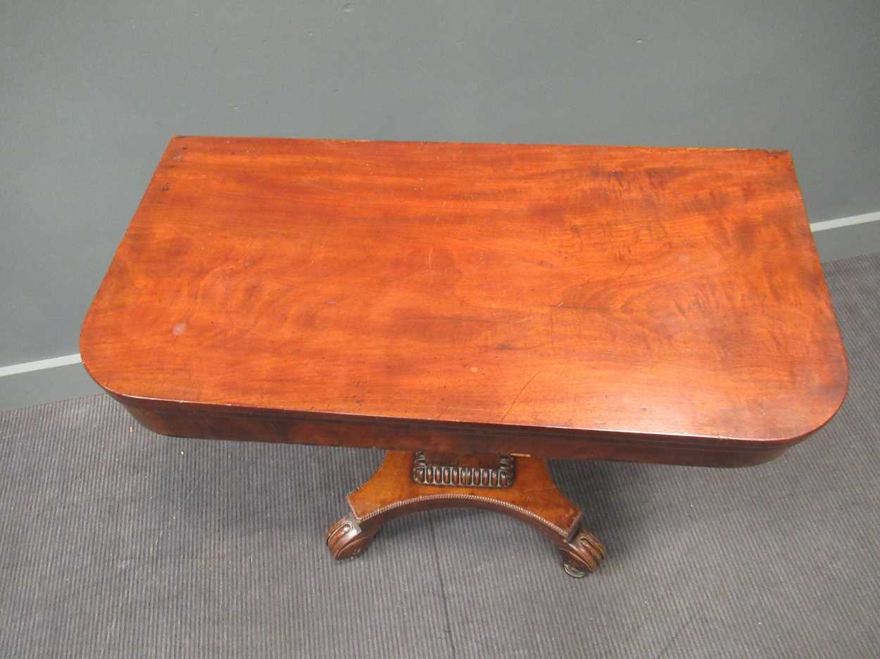 A Regency mahogany fold over tea table, the rounded rectangular top on a tapered column raised on - Image 2 of 9
