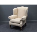 A modern DURESTA wing-back armchair on turned front legs, 112 x 96 x 78cm