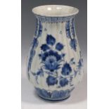 A blue and white Delft tulip vase with flared rim and ribbed sides, decorated with floral swags,