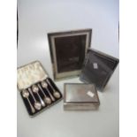 Six cased silver golfing teaspoons, a silver photo frame, a silver table cigarette box with