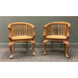 A pair of 20th century tub armchairs, with wavy stick backs and caned seats on cabriole front