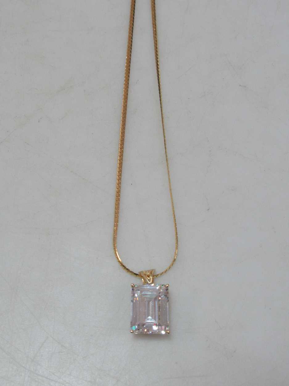 A cubic zirconia pendant hallmarked 14ct gold, suspended from a hallmarked 18ct gold chain, gross