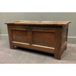 An 18th century oak coffer with hinge double panelled top, carved frieze and double panelled