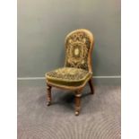 A late Victorian walnut and gilt slipper chair, the rounded back and seat upholstered in a floral