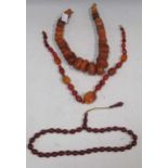 Two amber necklaces, together with a cherry coloured bead necklace, possibly bakelite (3)The