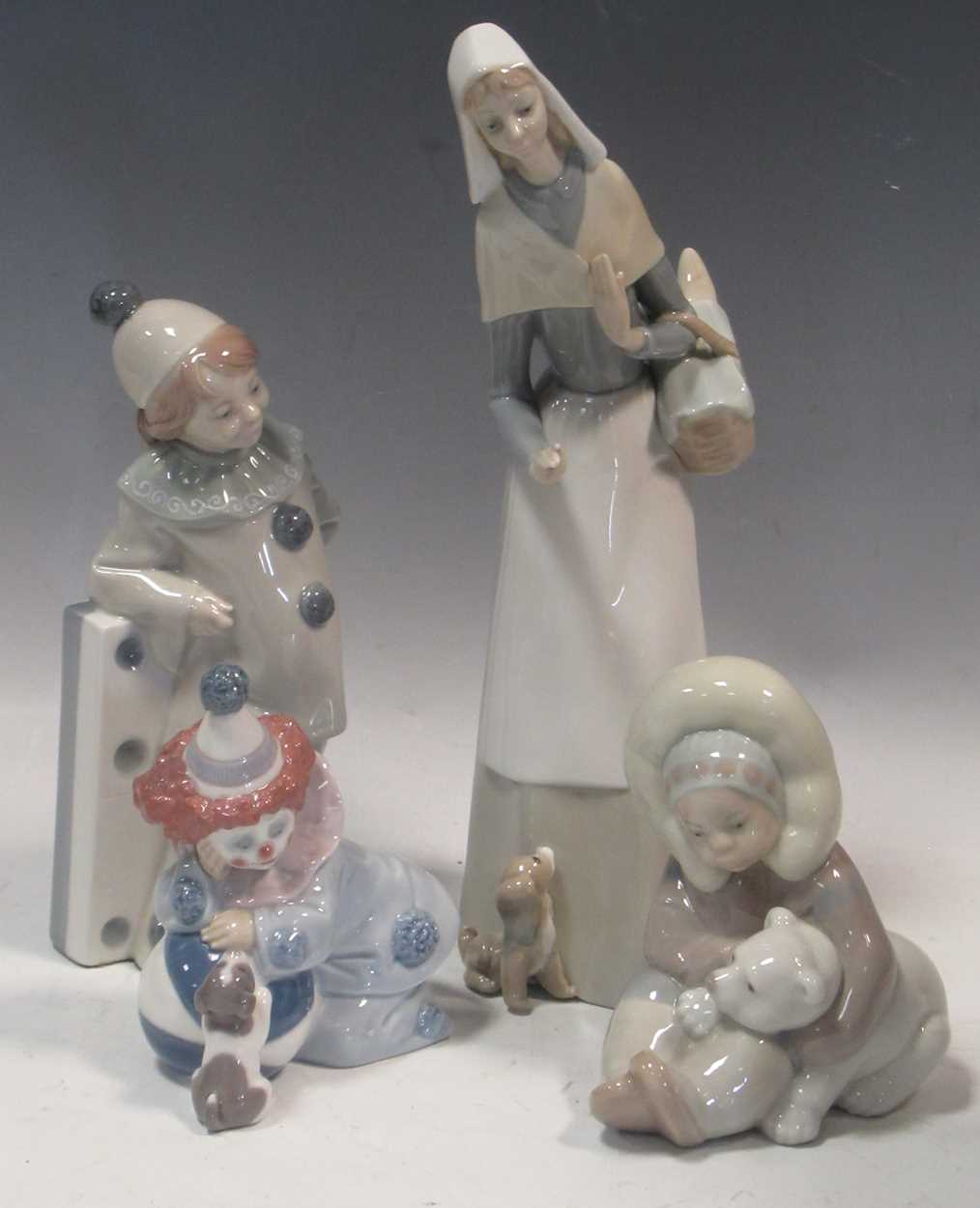 Four Lladro figures, to include 'Jester Clown Girl with Domino' #1175, 'Eskimo Playing' #1195,