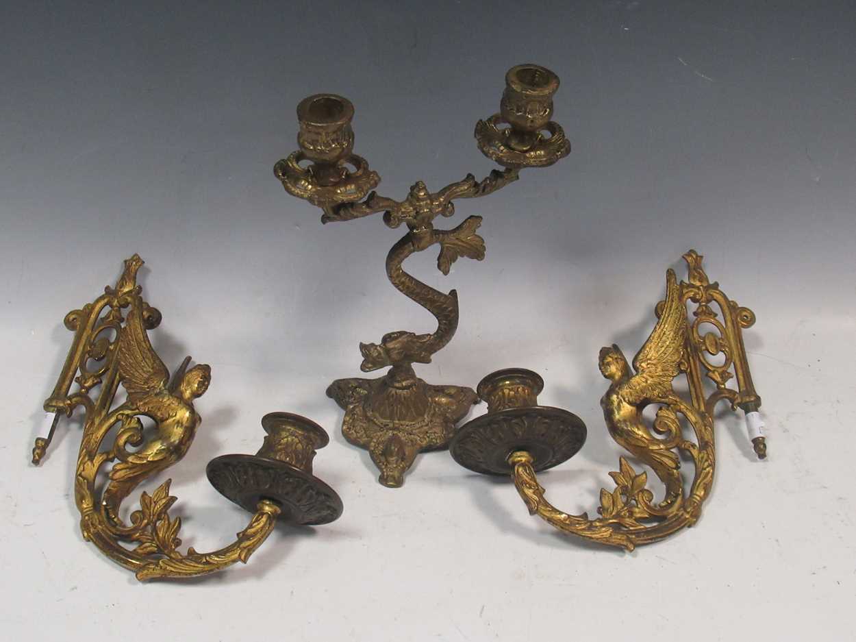 A pair of 19th century gilt metal wall sconces together with a brass candlestick with dolphin