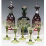 Various glasswares including two cranberry glass decanters, a set of five blown green glass wine