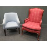An American style puce tartan upholstered wingback armchair; together with another blue