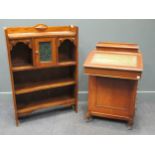 An Edwardian Arts & Crafts oak open bookcase, a central cupboard with a mottled green glazed door,