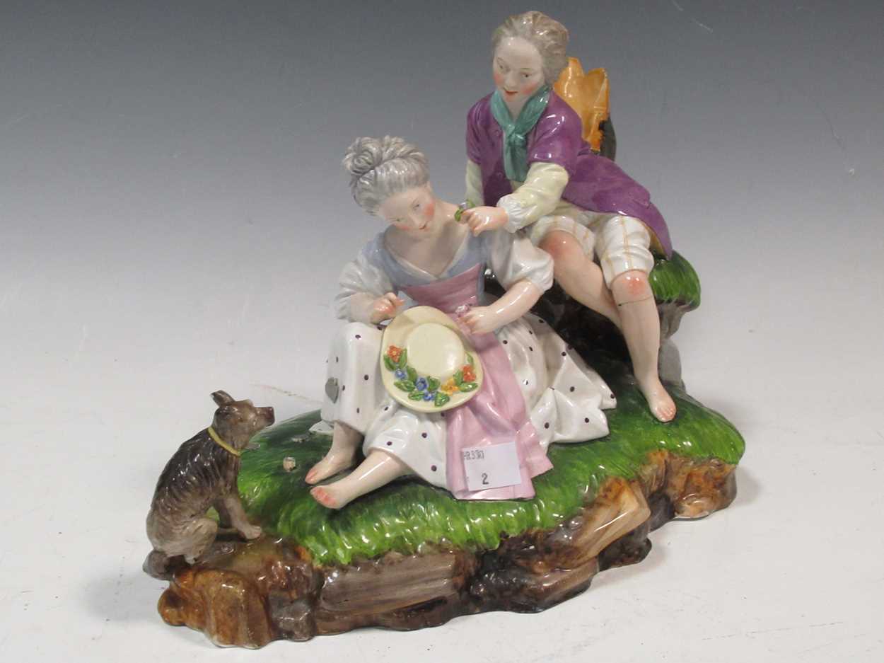 A Continental figure group of a courting couple with a dog, 22cm high